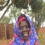 Smiling woman after receiving Aqiqah meat in Uganda