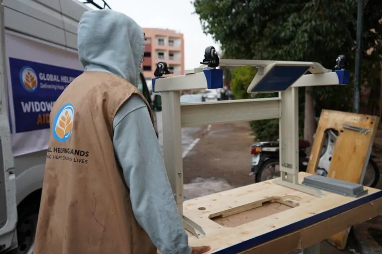 Volunteer carrying a sewing machine for a widow in Morocco