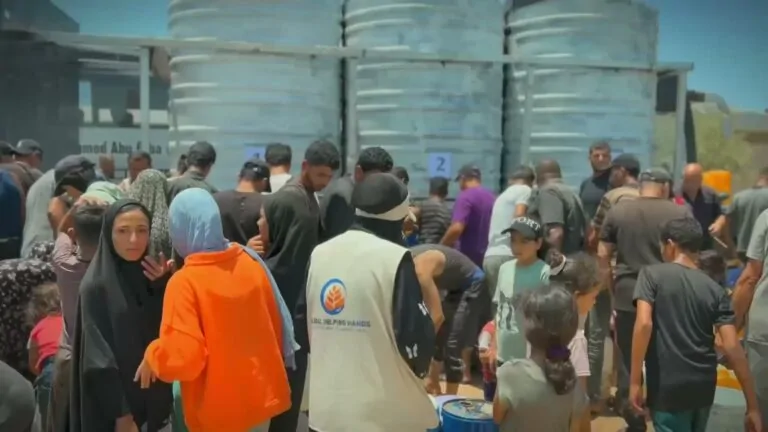 People queuing to fill containers from water tanks in Palestine