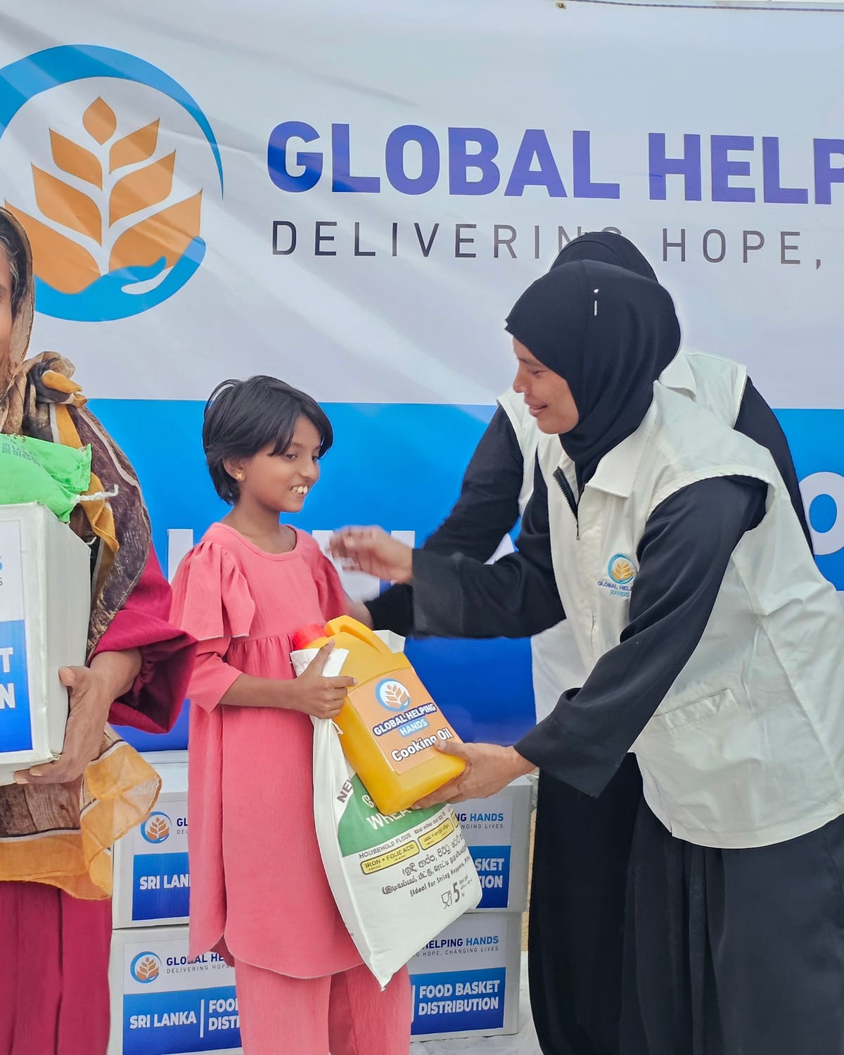 Girl receiving a food basket in Sri Lanka